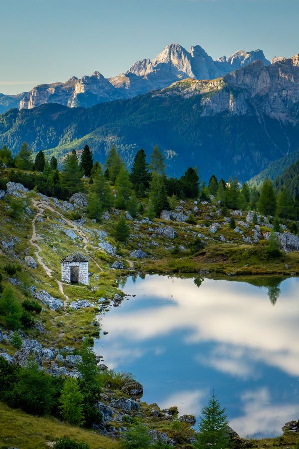 A stone hut by an alpine lake